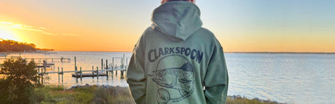 Person wearing Clarkspoon hoodie watching sunset