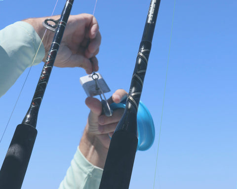 Connecting fishing planer to swivel with blue sky background
